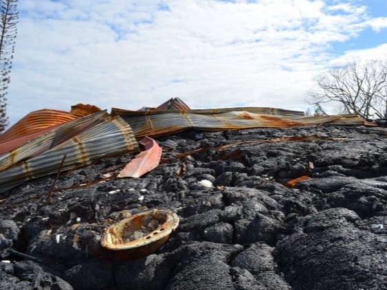 A metal roof and a bathroom sink—almost the only remains of a home shortly after a lava flow came through Pahoa, Hawaii, in 2014. Credit: Kevin Krajick/Earth Institute