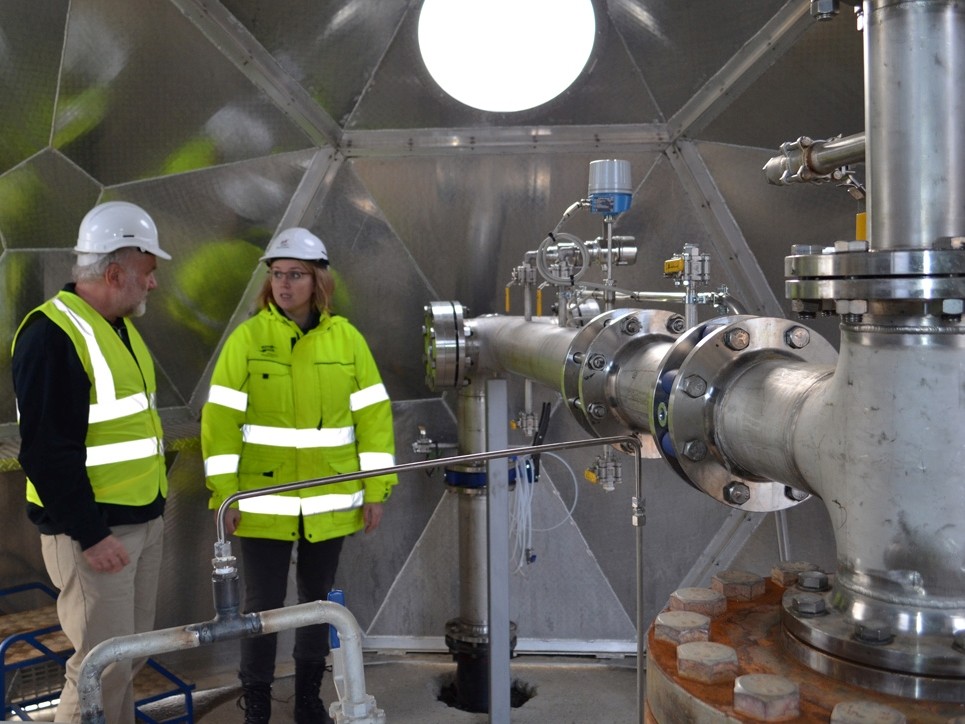 Martin Stute and Edda Sif Arradotir of Reykjavik Energy in front of a piping system that pumps CO2 emissions underground at the Hellisheidi power plant. Credit: Kevin Krajick
