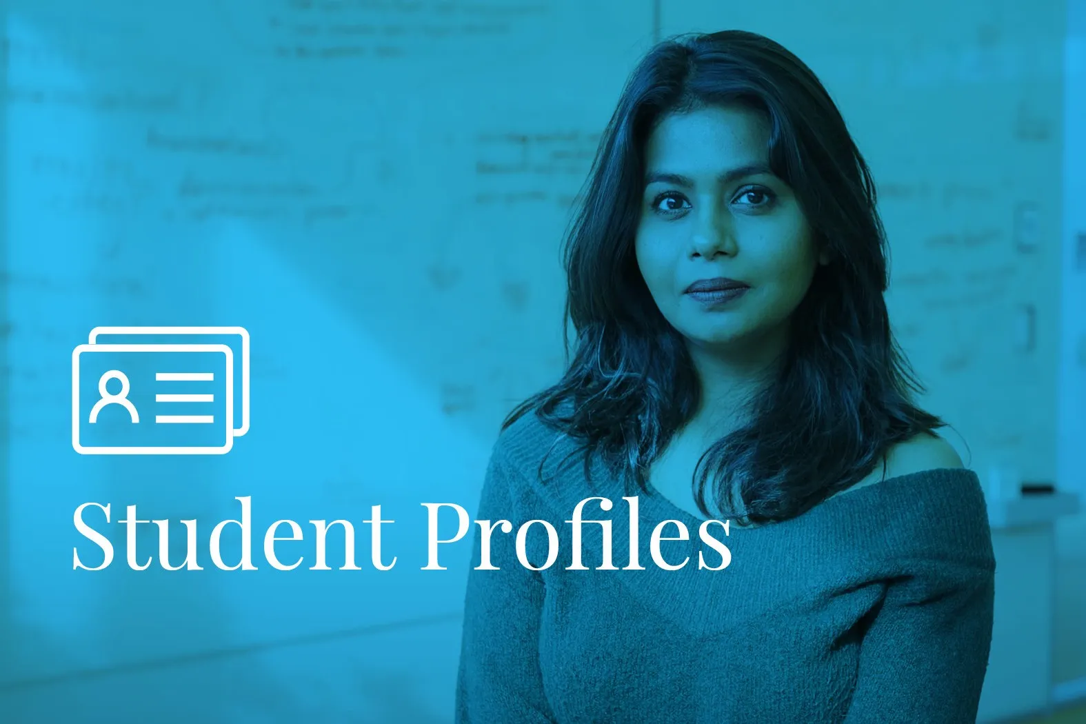 Woman smiling in front of a whiteboard with text Student Profiles