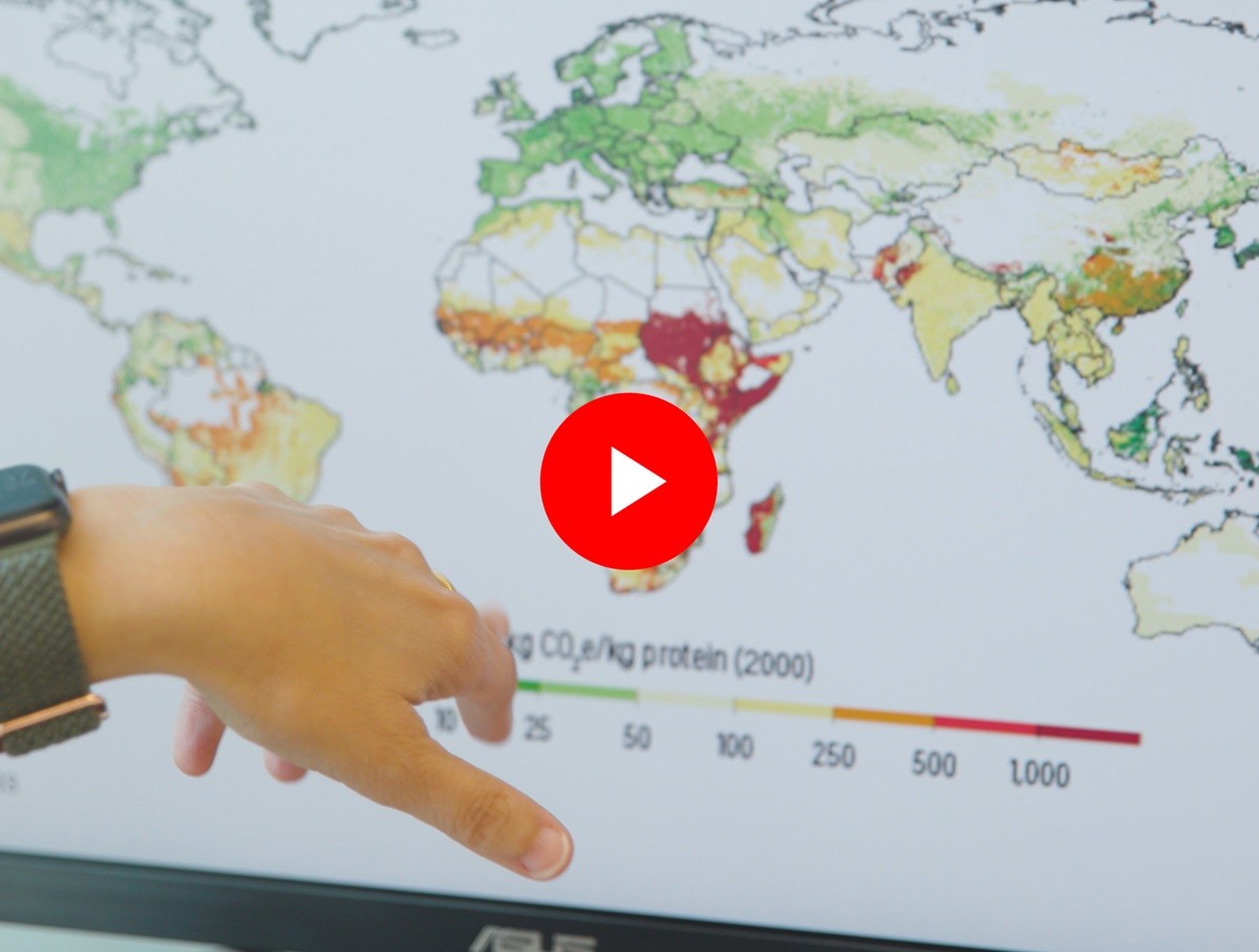 Hand pointing to a map on a computer screen