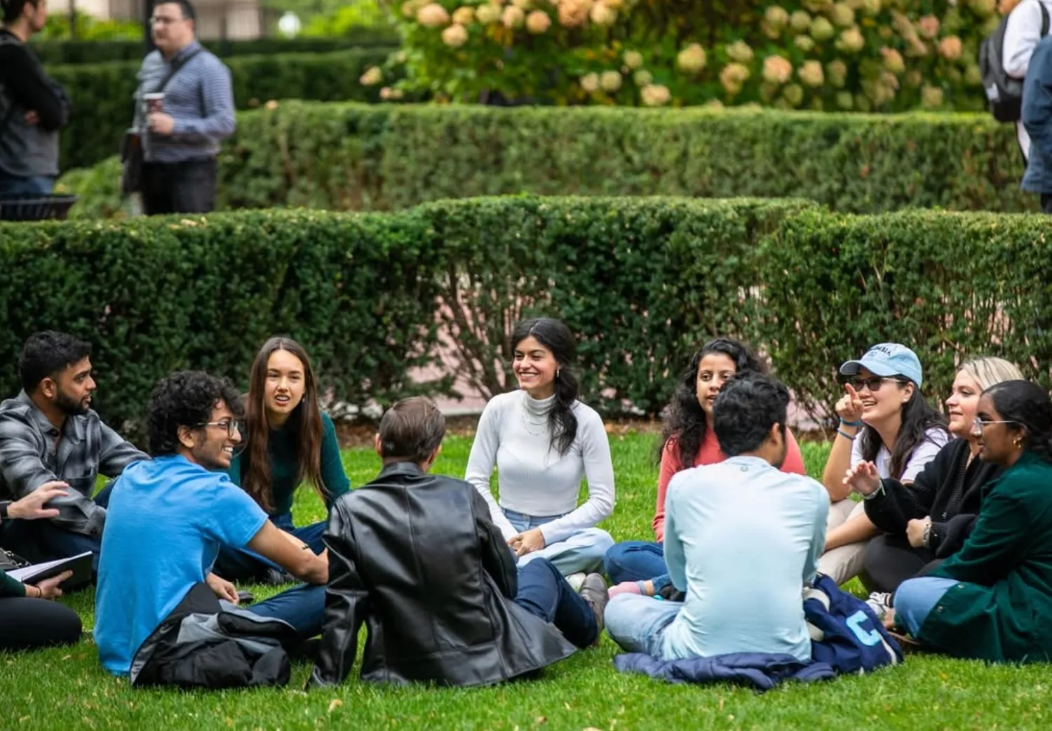 Group of students sitting in a circle on the grass