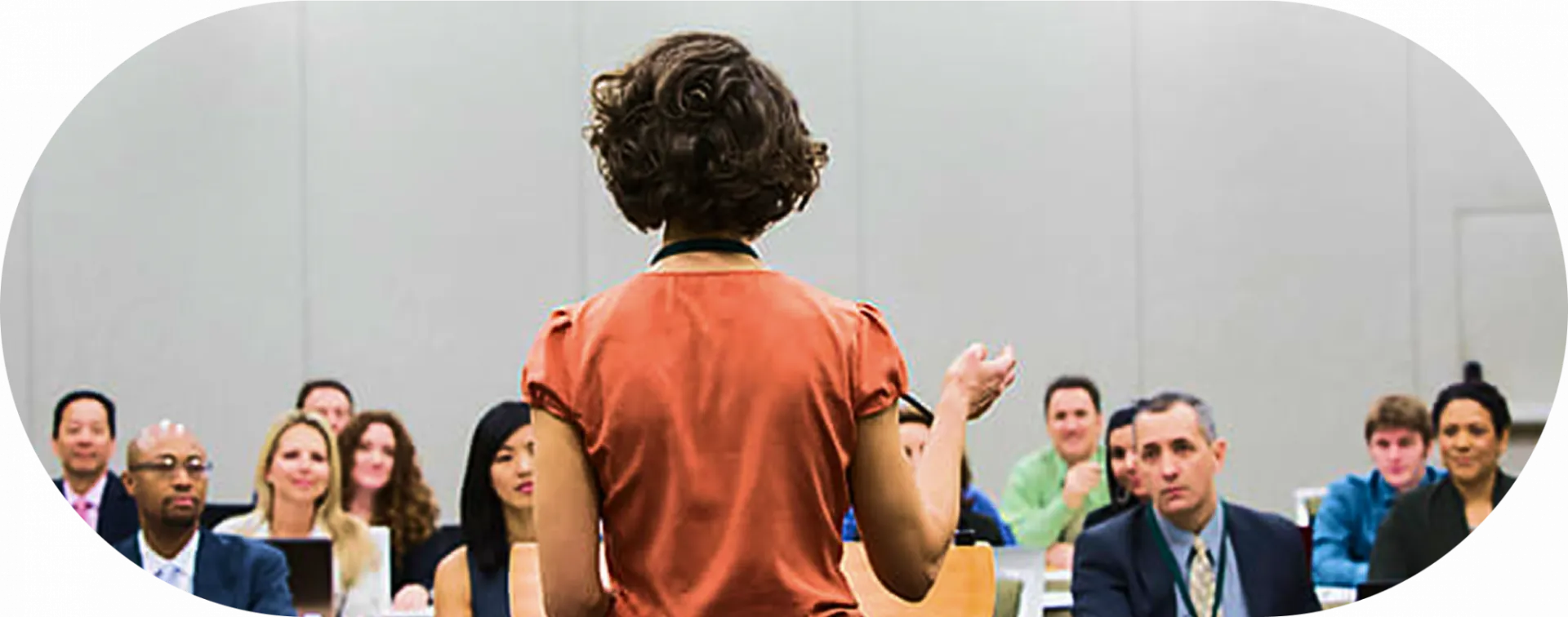 Woman seen from the back talking to a group of people dressed in business attire