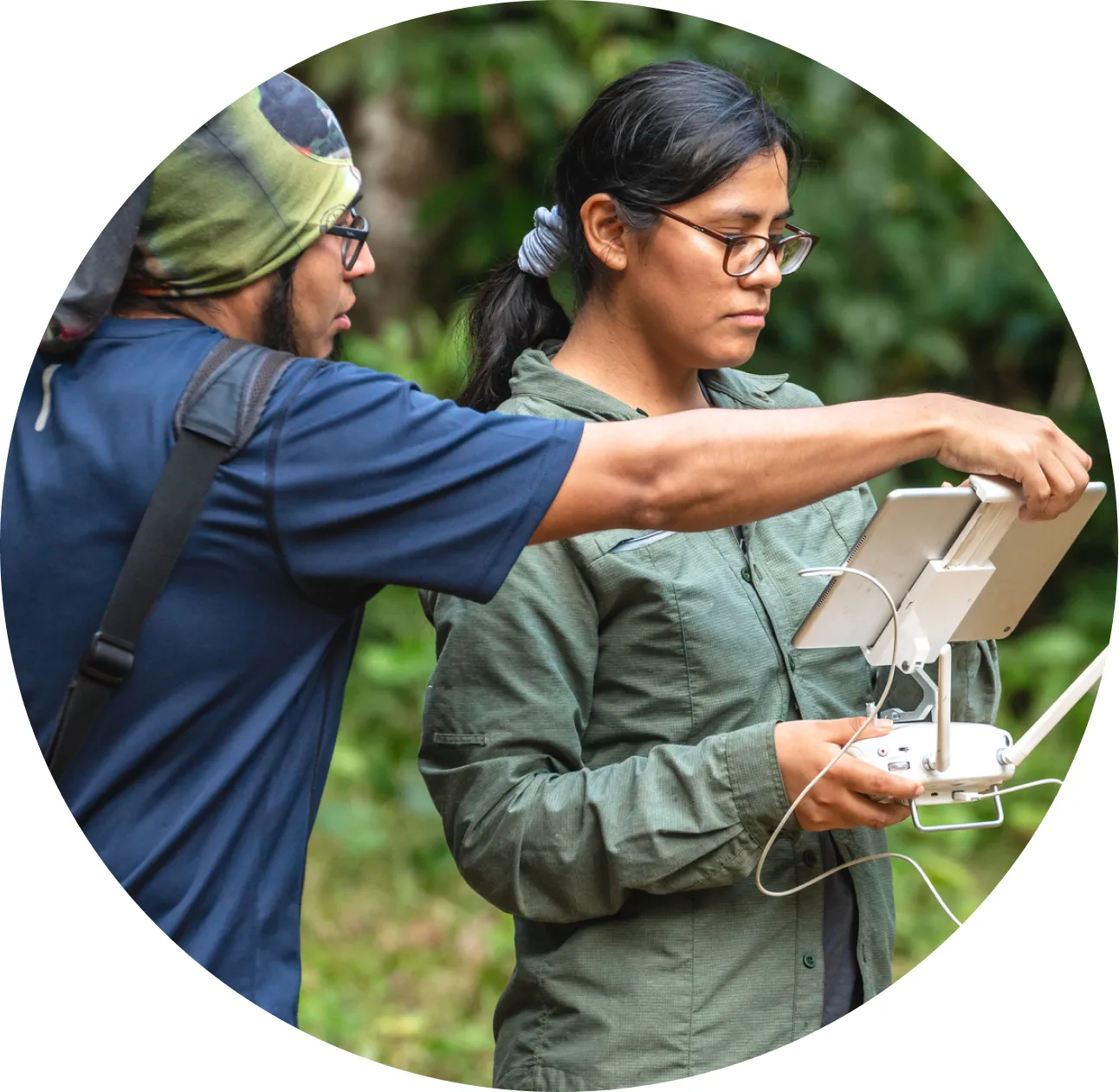 Two people in the field looking at a handheld device.
