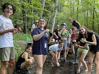 Group of teens gathered in a forest stream