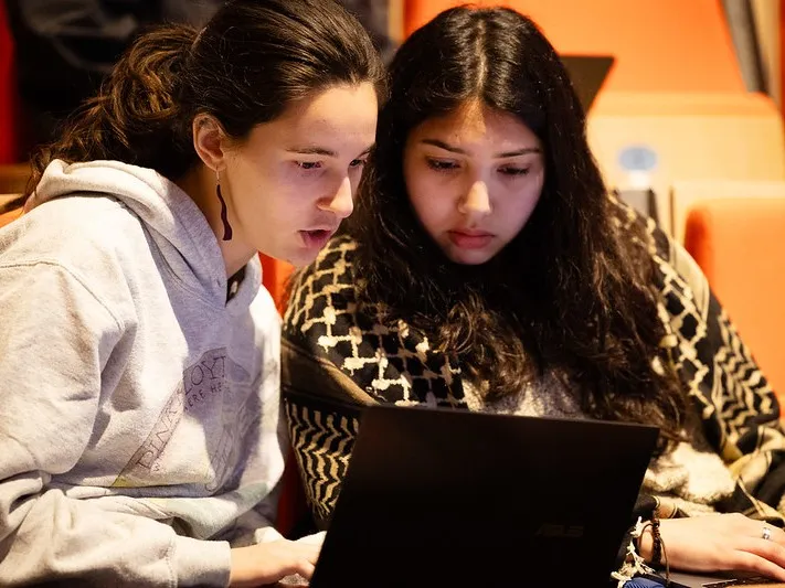 Two students looking at a laptop
