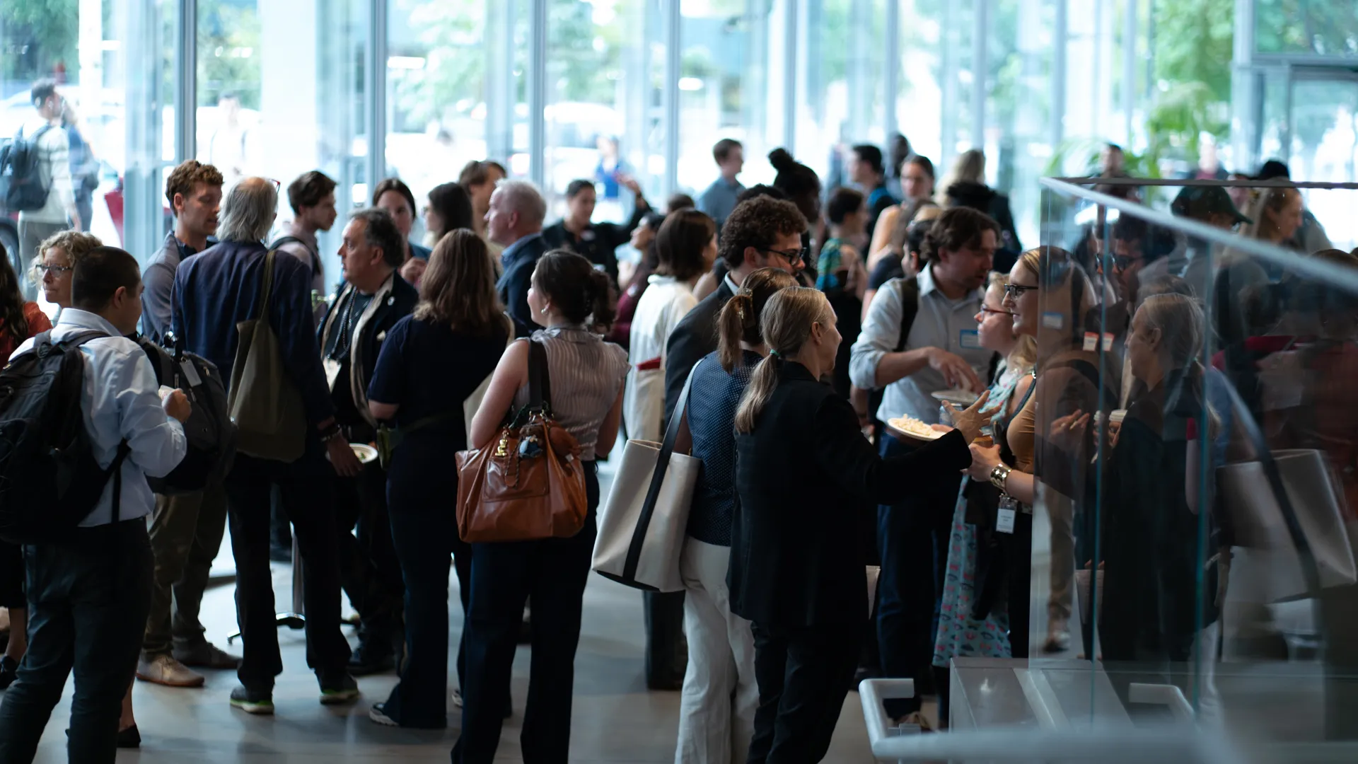 Large group of people networking in a light-filled building