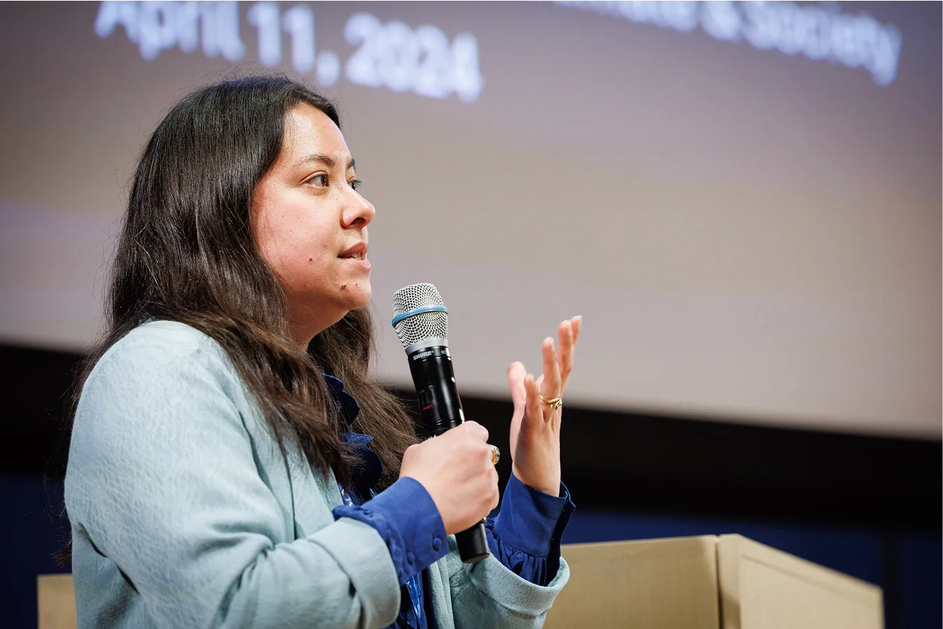 Woman holding a microphone and speaking