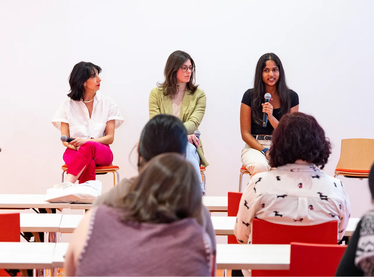 Three panelists address a classroom of students