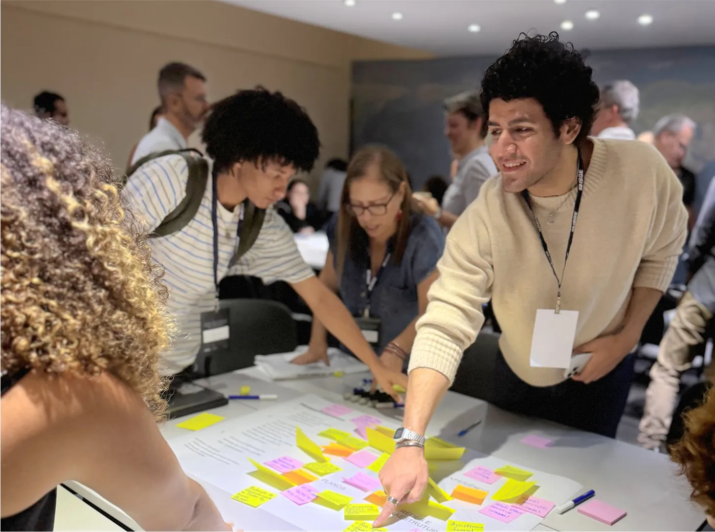 People wearing lanyards arranging colorful sticky notes on a table