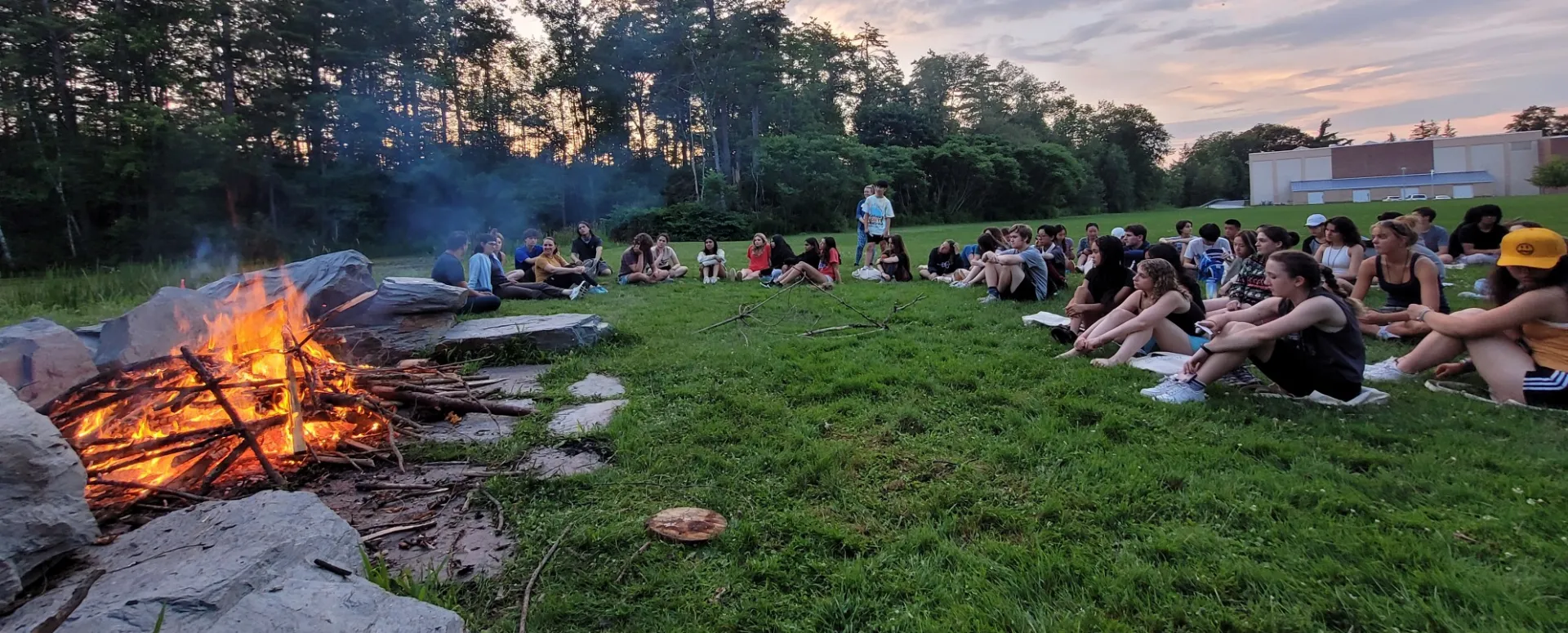 Students sitting around the bonfire. 