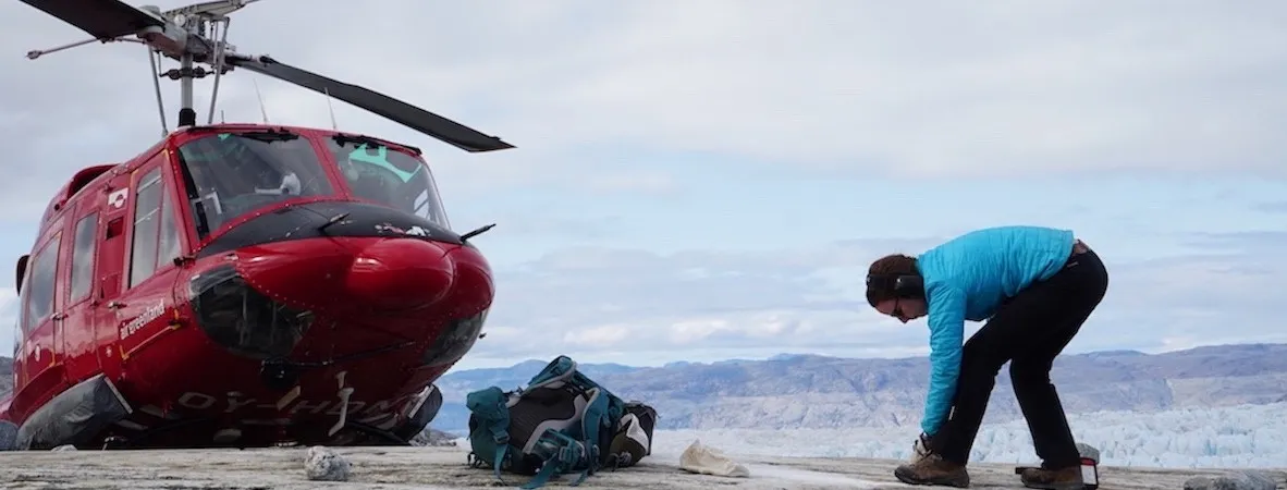 Picture of a person next to an helicopter