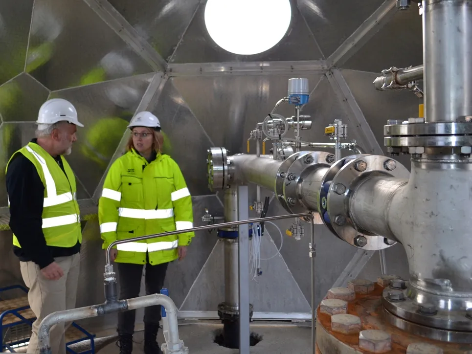 Martin Stute and Edda Sif Arradotir of Reykjavik Energy in front of a piping system that pumps CO2 emissions underground at the Hellisheidi power plant. Credit: Kevin Krajick
