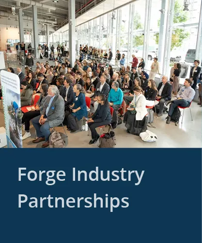 Large group of people watching a presentation with the text Forge Industry Partnerships